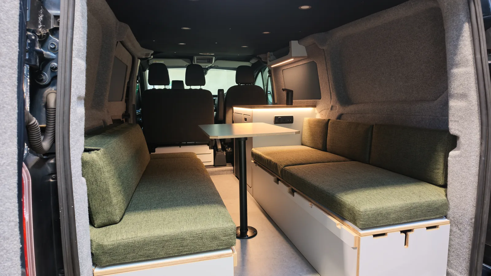 THE CUSHION - Product photograph Green made-to-measure seating cushions inside a converted van